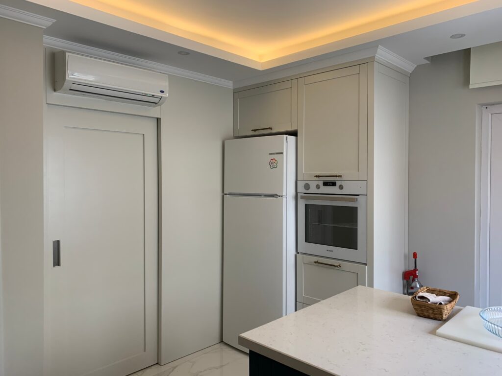 Modern Villa İç Mimarlık Projesi Ankastre fırın ve buzdolabının yerleşimini gösteren, tamamlanmış mutfağın yakın çekim gerçek fotoğrafı.