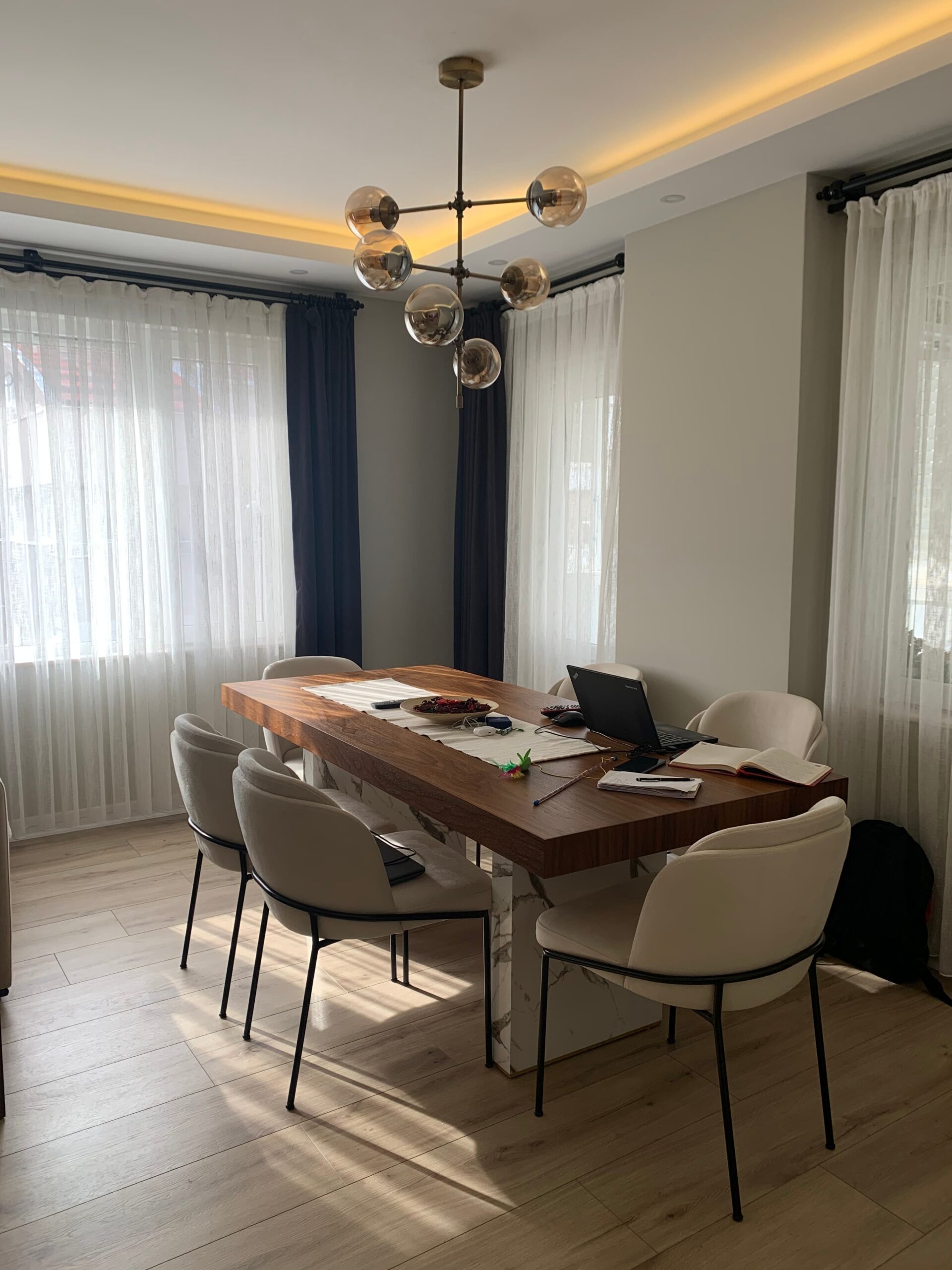 Ahşap masanın ve modern sandalyelerin yer aldığı, tamamlanmış yemek odasının gerçek fotoğrafı.