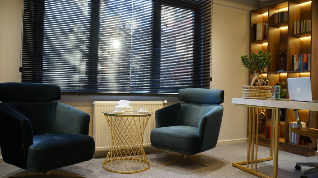 Psikolojik Danışmanlık Ofis Tasarımı Şık koltuklar ve modern sehpa ile tasarlanmış, danışanları karşılamak için konforlu oturma alanı.