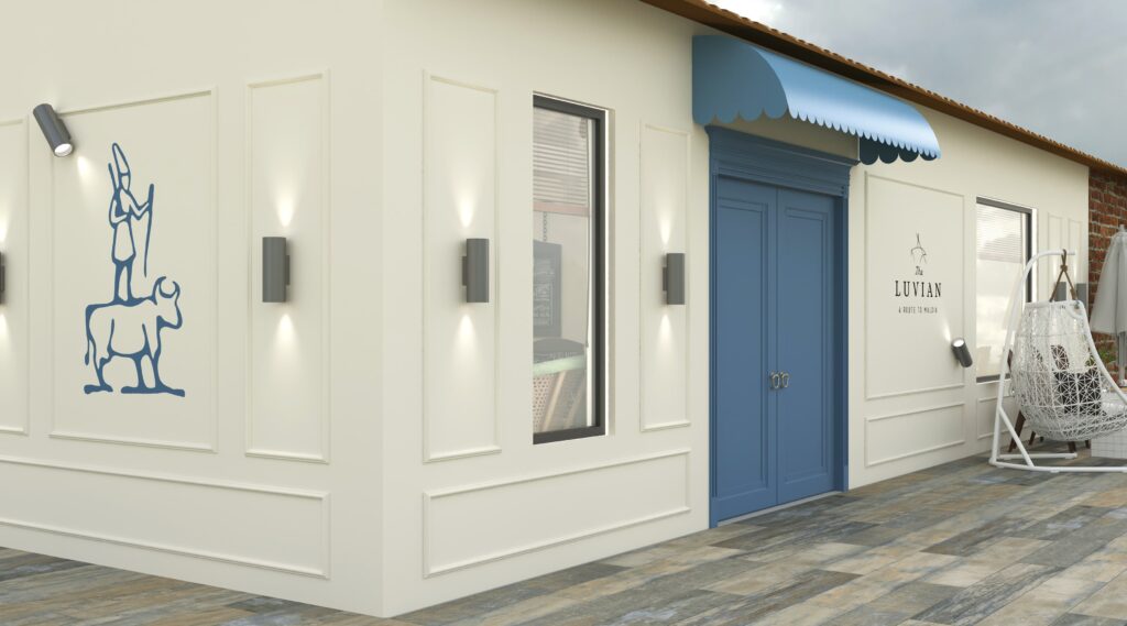 Butik Kafe Tasarımı Beyaz duvar panelleri, modern dış mekan aydınlatmaları ve duvar sanatı figürleriyle kafe dış cephe detayı.